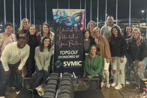 Healthcare Leaders Association attendees pose at Top Golf.